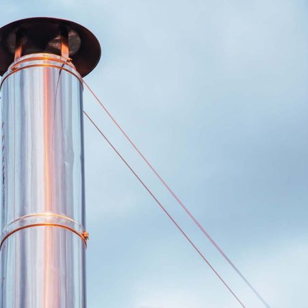Exterior metal chimney pipe on top of a roof.