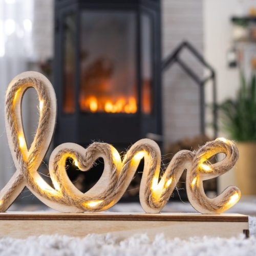 Valentine decor near fireplace stove with fire and firewood